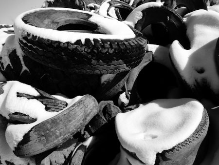A lot of old tires in the snow. Black and white photos.の写真素材
