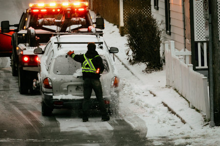 Towing a car with snow on the road during a winter snowfall.