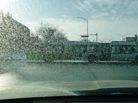 View of the road through the icy windshield of a car. A bus on the road in winter. Reduced visibility.の写真素材