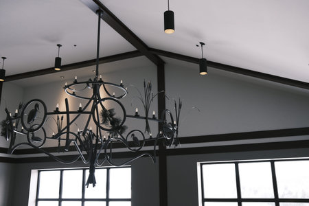 Chandelier in the interior of the room with large windows.