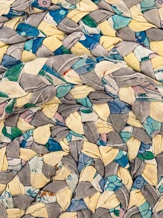 Texture, background, pattern. The fabric is multi-colored with a patchwork pattern of geometric shapes. Close-up of a colorful braided rug as a background texture pattern.の写真素材