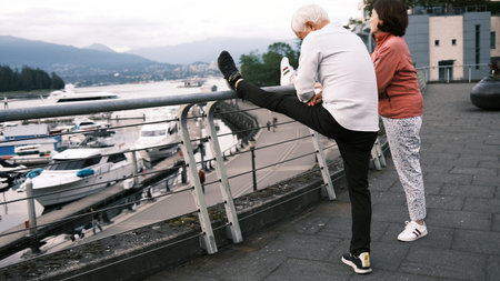 Elderly man doing stretching exercise on the promenade in Vancouver