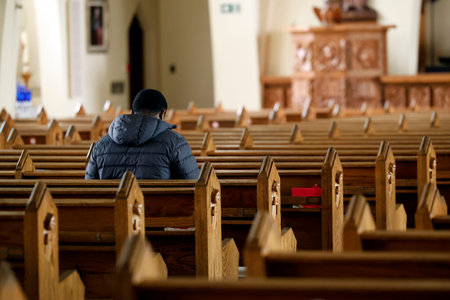 Man praying in the church. Selective focus on the man