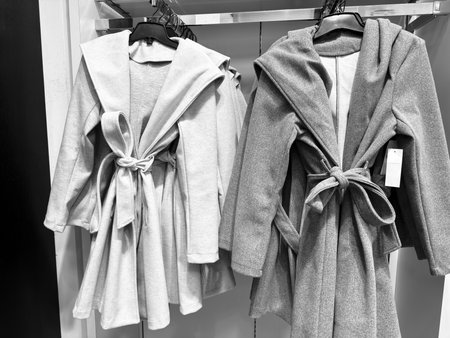 Woman's bathrobe on hangers in the store. Black and white.の写真素材