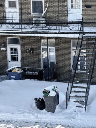 An apartment building in winter with trash can and stairs.のeditorial素材