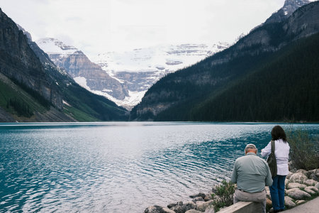 Couple looking at a Lake Louise, Banff National Park, Alberta, Canada.の写真素材
