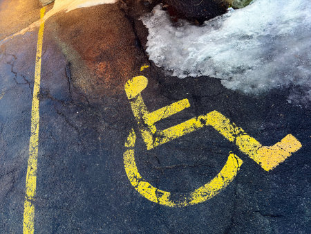 Disabled parking sign painted on the asphalt in winter. Wheelchair symbol.の写真素材