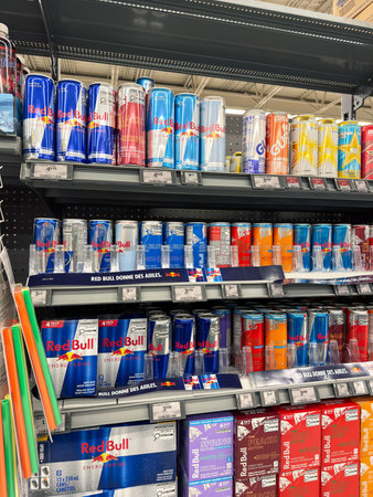 Supermarket shelf with a lot of soda cans. Shelves with cans of Red Bull in the hypermarket.