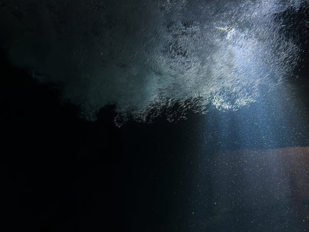 Underwater view of the surface of the sea with sunlight and bubbles