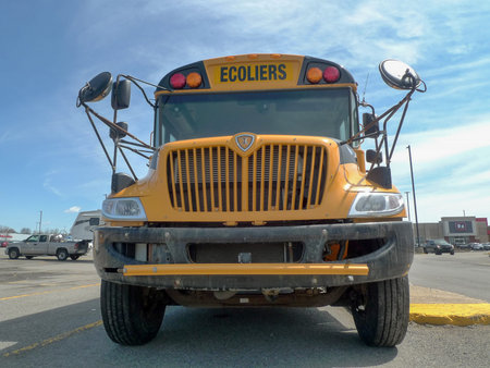 Yellow school bus parked in a parking lot in Quebec city.