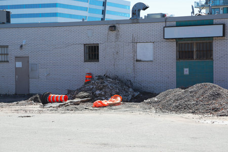 Construction site of an old building in the city. Building materials with a broken wall and orange...
