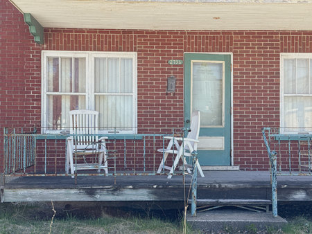 Old house with two chairs on a wooden porch.の写真素材