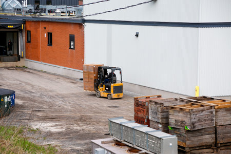 A forklift unloads cargo from a cargo container into a warehouse