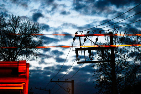 Electricity pylon with wires at sunset in the evening. Selective focus.の写真素材