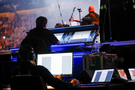 Sound engineer working on a digital mixing console in a live concert. Sound technician at a music...