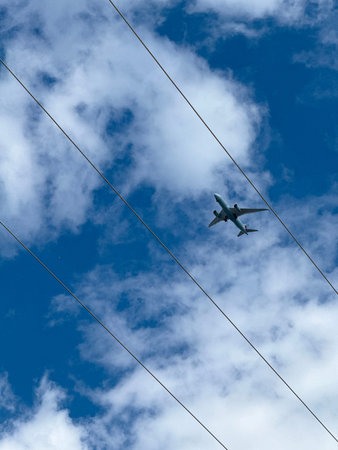 Airplane flying in the blue sky with white clouds on a wire. An Air Canada is flying.