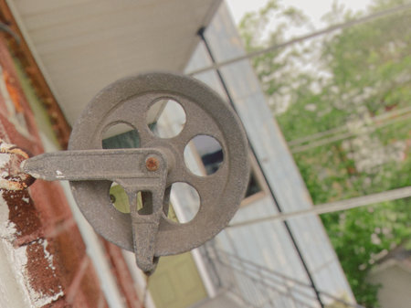 An old clothesline pulley on an apartment balcony.