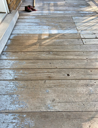 Wooden floor with shoes on the background of the shadow of the sunの写真素材