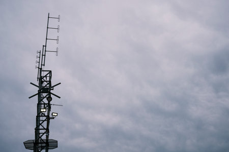 Telecommunications tower on cloudy sky background. Technology and communication concept.の写真素材
