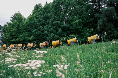 Snow cannons on the green meadow in the mountains in summer at a ski resort.の写真素材