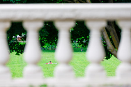 Woman relaxing on a green lawn in a public park, summertime