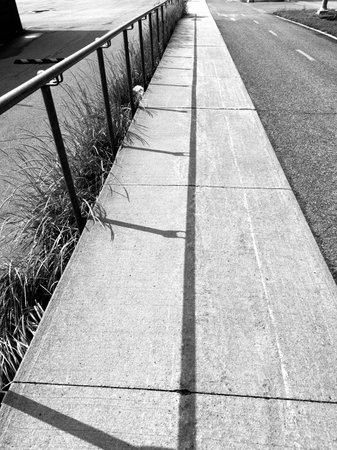 Perspective view of a walkway with shadow on the ground. Black and white.の写真素材