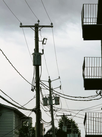 Electricity post on the street with cloudy sky background.の写真素材