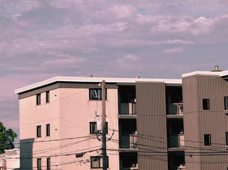 Apartment buildings on a sunny day. An electric pole.