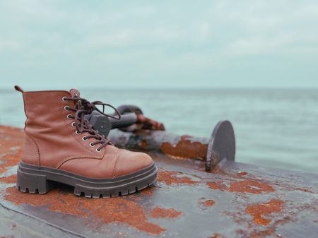 Pair of hiking boots on the pier with sea in the background