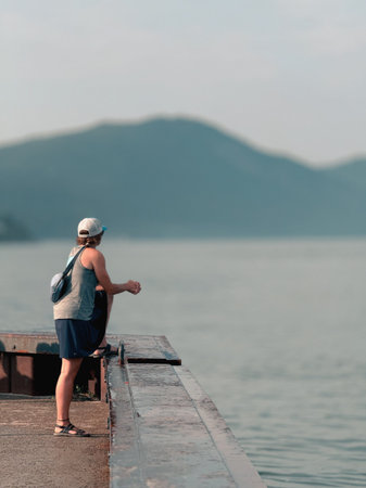 Woman standing on a pier and looking at the sea