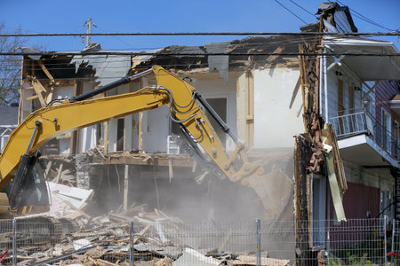 Demolition of an old house with a yellow excavator at a construction site. Demolition of an...