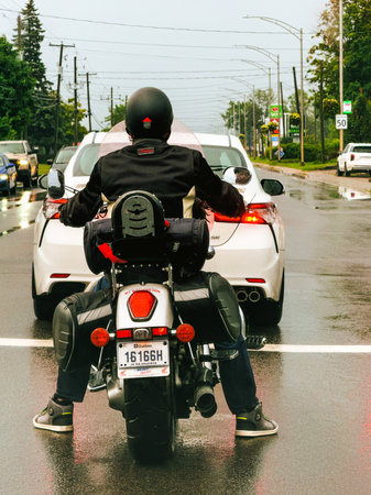 A motorcyclist on a motorcycle in Quebec City on a rainy day.のeditorial素材