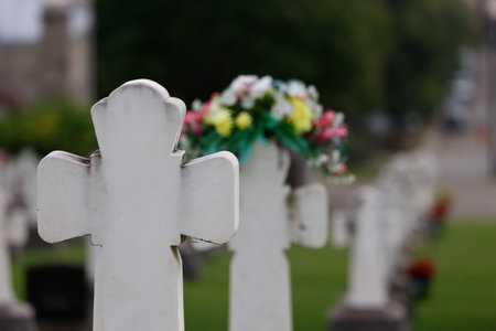Cross with flowers on the background of the grave in the cemetery in Quebec