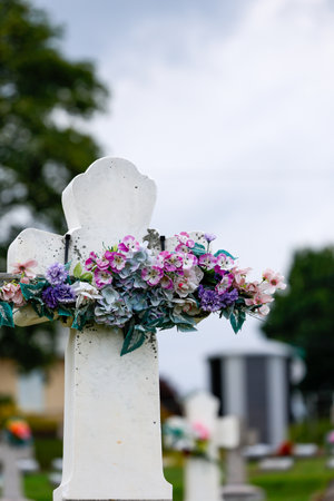 Cemetery with a stone cross and a bouquet of flowers.の写真素材