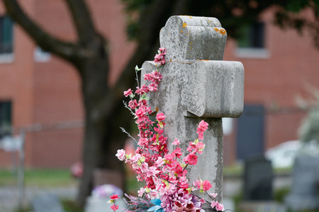 Cemetery with a stone cross and a bouquet of flowers.の写真素材
