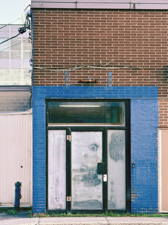 Brick facade of an industrial building with a closed door. Toned.の写真素材