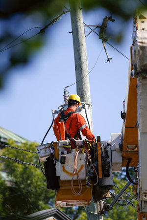 Electrician working on a power pole. A worker works on electrical wires. Workers on the construction...