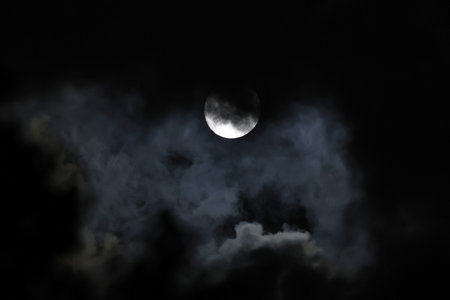Full moon in the night sky with dark clouds, closeup of photoの写真素材