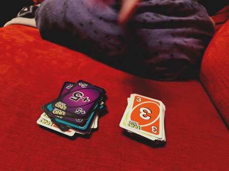 Playing Uno cards on a red background, close-up, selective focus