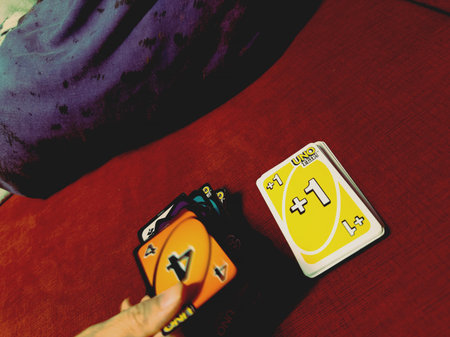 Playing Uno cards on a red background, close-up, selective focusのeditorial素材