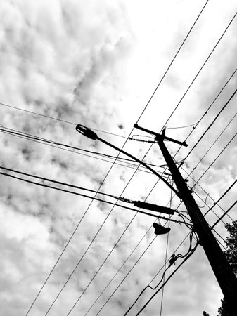 electricity post and cloudy sky in black and white. High quality photo