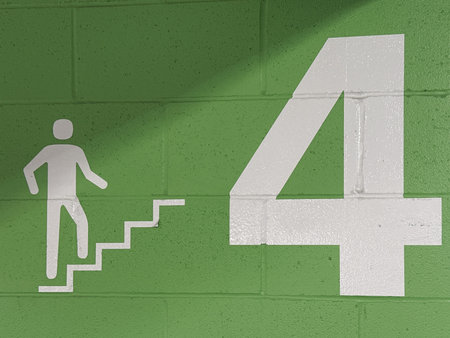 Emergency exit sign on the wall with shadow.