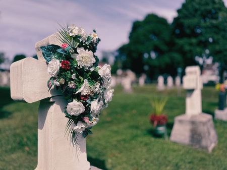 Flowers on a cross in a cemetery in Quebec.の写真素材