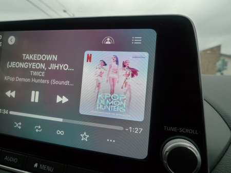 Car on the road with smartphone app on the screen. App for listening to music in the car.