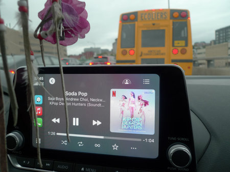 Car on the road with smartphone app on the screen. App for listening to music in the car.
