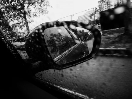 Rain drops on the side mirror of a car. Black and white