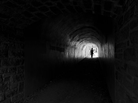 A woman walking in a tunnel. Black and white photos.のeditorial素材