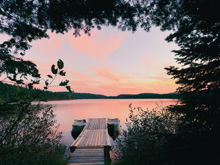 Fishing boat on the lake at sunset. A lake at sunset in the forest.の写真素材