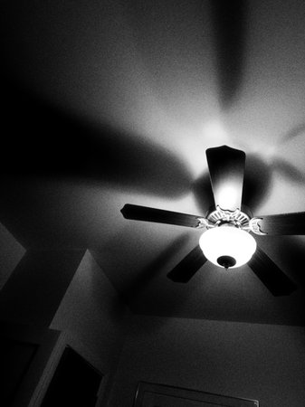 Ceiling fan in black and white with light from the ceilingの写真素材