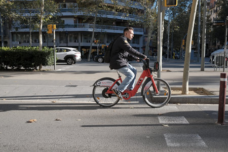 Cyclist in Barcelona, Spain. Red rental bikes are available in the city of Barcelona.